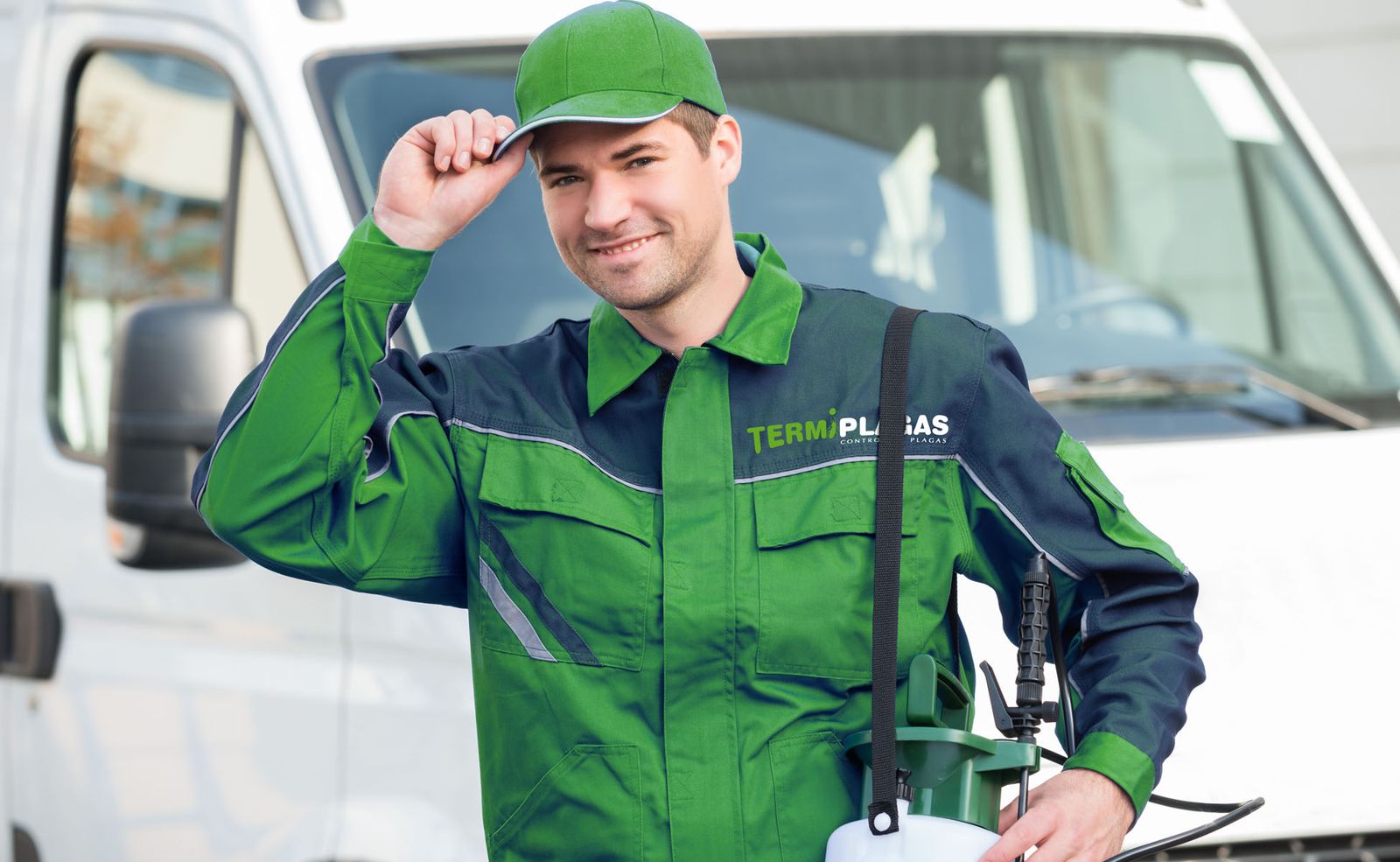 Técnico de Termiplagas con el uniforme de la empresa y un pulverizador, delante de la furgoneta